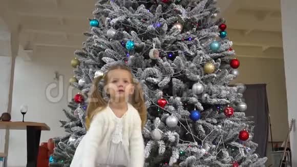 小可爱的女孩把礼物盒和圣诞树放在一起视频的预览图