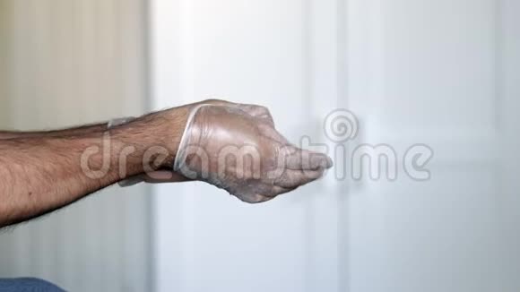 男性在家中脱下医用乳胶手套保护冠状病毒视频的预览图