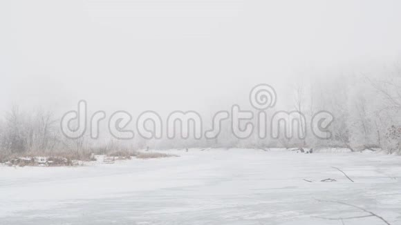雾中的冬河冰上钓鱼的渔民视频的预览图