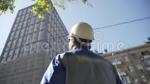 建设者看新的建筑工地戴安全帽的工人看新的建筑结构成功的肖像视频的预览图