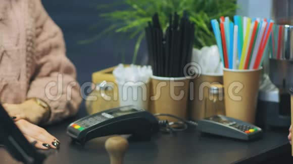 女客户在咖啡馆里拿着带帽子的纸杯咖啡视频的预览图