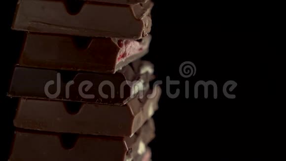关闭镜头塔的碎片不同块巧克力旋转在一个黑色的背景草莓马斯卡彭视频的预览图