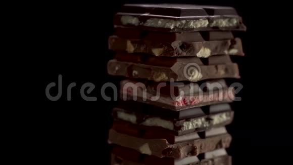 不同大块的巧克力在黑色背景上旋转草莓马斯卡彭坚果牛奶和视频的预览图