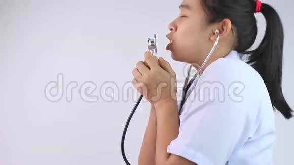 年轻女医生用听诊器唱歌在白色背景上跳舞视频的预览图