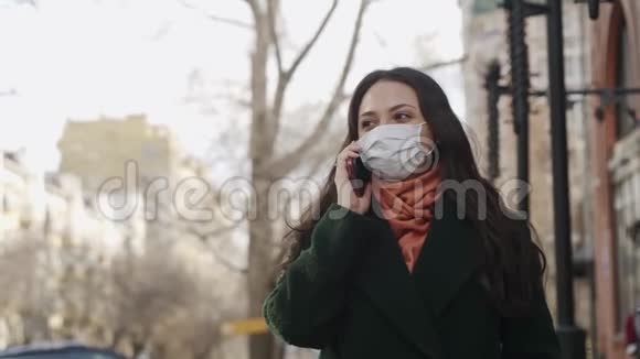 戴口罩的女人一边咳嗽一边说手机流行冠状病毒视频的预览图