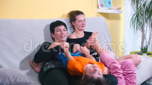 两位母亲和他们的儿子和女儿坐在酒店房间里视频的预览图