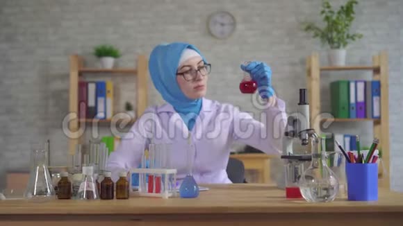 一位年轻的穆斯林女科学家在实验室工作戴着国家围巾视频的预览图