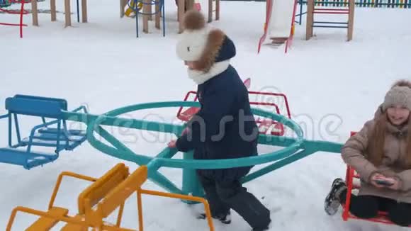 冬天快乐可爱的女孩一起玩旋转木马视频的预览图