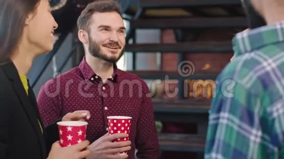 一个魅力四射的家伙面带微笑的上班族边喝咖啡边和下班的同事聊天视频的预览图