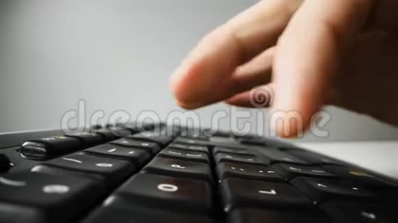 手指在黑色电脑键盘上打字小娃娃特写镜头视频的预览图