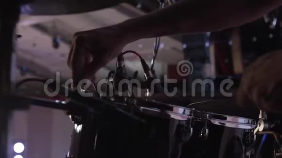 紧紧抓住鼓手一个人在现场表演前调整设备排练一个声音鼓手视频的预览图