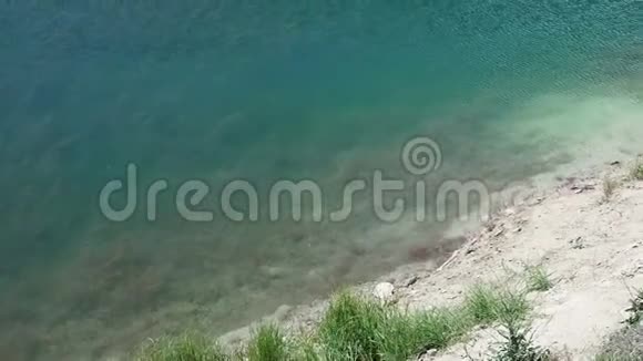 一个闪闪发光的蓝色绿色湖泊的俯视图视频的预览图