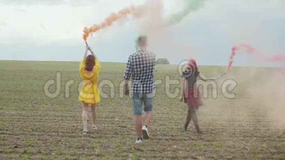 时髦的嬉皮士穿着彩色的烟走过田野视频的预览图