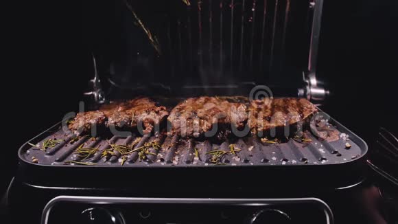 美味多汁的肉排在烤架上烹饪陈年珍贵烤大理石牛肉电烤炉迷迭香视频的预览图