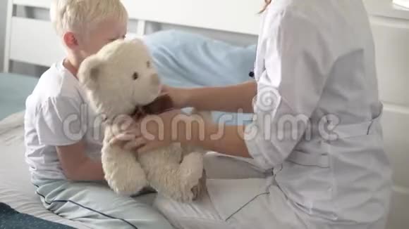 一名护士从医院的拳击中给一个孩子服用一种维生素然后把它交给病房里的孩子视频的预览图