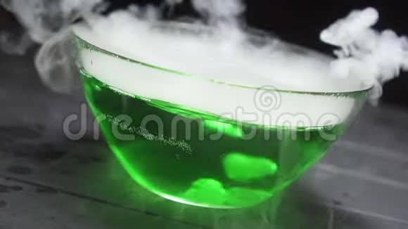 黑色背景下沸腾的绿色液体中的气体气泡视频的预览图