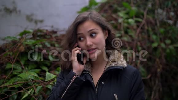惹眼的年轻混搭女人在外面打电话穿着冬衣视频的预览图