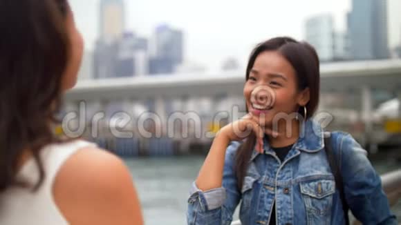 年轻女子在码头边听朋友说话微笑视频的预览图