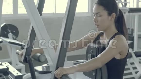 美丽的亚洲年轻女子健身训练臂在健身房健身视频的预览图
