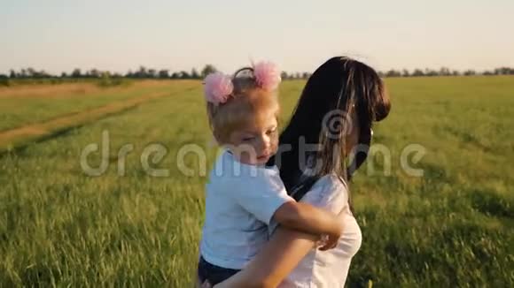 一个幸福的家庭妈妈肩上扛着一个漂亮的小女儿夕阳西下走在绿油油的田野里这就是视频的预览图