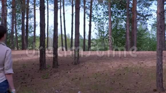 女人带着倒下的树木到森林童子军的营地寻找柴火后景视频的预览图