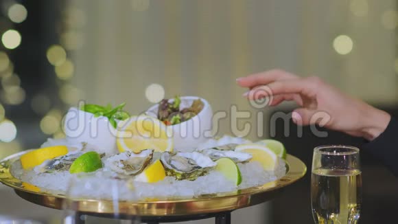 女人挤柠檬片往牡蛎里撒果汁视频的预览图