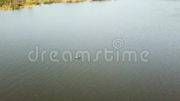 空中无人机在湖上的一艘小渔船上向渔民射击美丽的夏日风景湖鸟瞰图视频的预览图