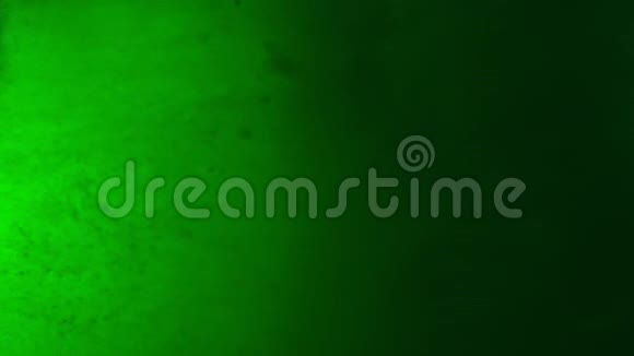 绿色油漆滴在水中混合缓慢运动光滑的墨水从水下旋转和飞溅墨上筠视频的预览图