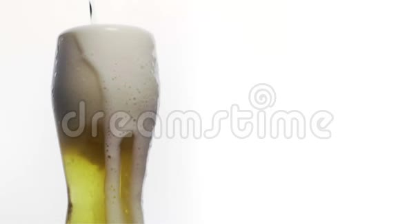 白色背景上有啤酒的玻璃中冒出细泡啤酒杯特写慢动作泡沫2视频的预览图
