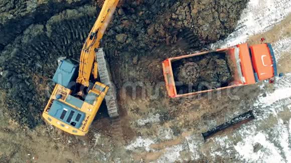 工业采石场施工挖掘机工作一台带桶的机器在职业生涯中装载一辆卡车视频的预览图