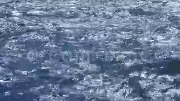 蓝色的海浪和涟漪的特写在海水上闪耀着明亮的耀斑视频的预览图