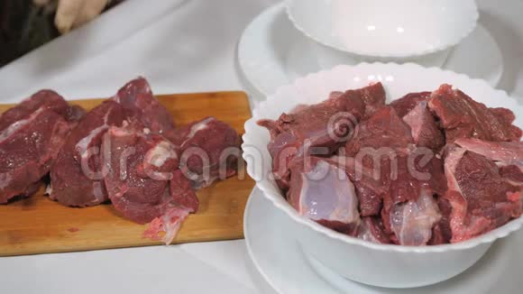 野麋鹿肉的切割深色生肉加工在木切割板上切割把肉转移到碗里视频的预览图