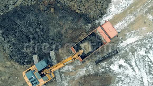工作挖掘机在职业生涯中装载一辆装有石头的卡车工业采石场施工挖掘机工作视频的预览图