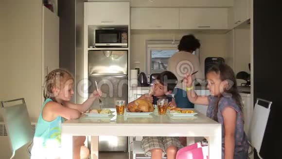 孩子们在妈妈提供的厨房餐桌上吃饭视频的预览图