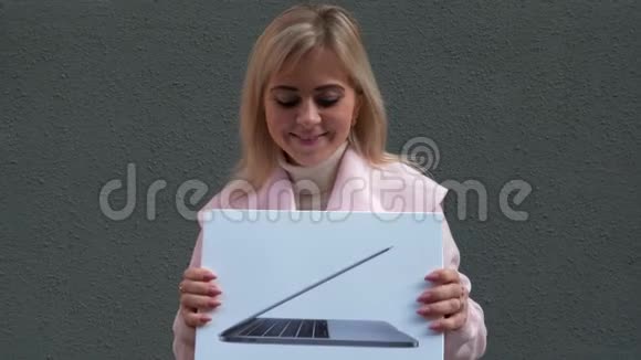 这位女士手里拿着笔记本电脑包微笑着跳舞从幸福中跳出来视频的预览图