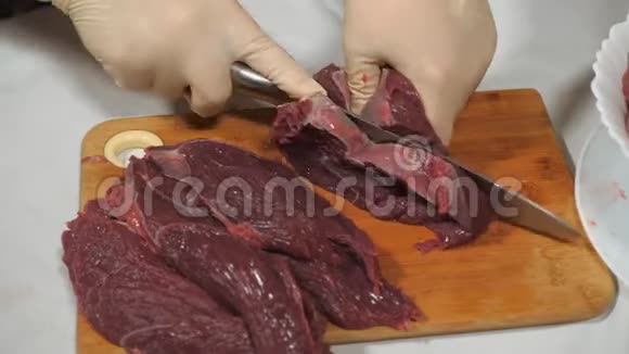 野麋鹿肉的切割深色生肉加工在木切割板上切割视频的预览图
