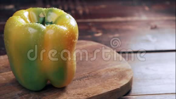 厨师用一张旧木桌在厨房的切割板上切一个橙色的辣椒片视频的预览图