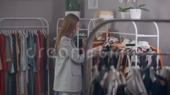 购物时尚风格和人的概念快乐的女人在商场或服装中选择衣服和镜子视频的预览图
