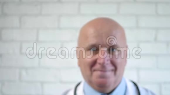 医生在窗后微笑着做手势让他把手放在玻璃上视频的预览图