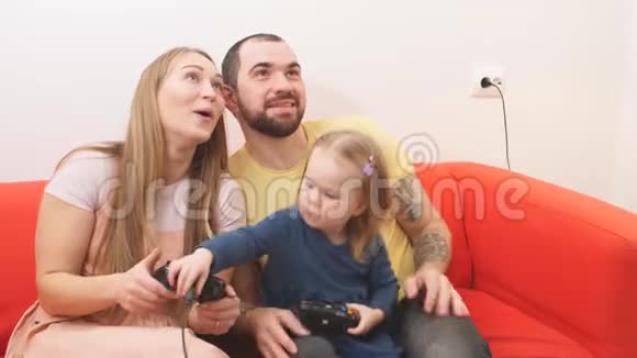 有趣的父母和孩子坐在玩电子游戏视频的预览图