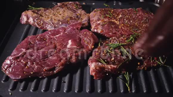 美味多汁的肉排在烤架上烹饪电烤炉上的优质牛肉迷迭香黑胡椒盐慢慢视频的预览图