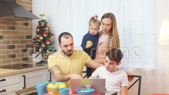 白人家庭在吃早餐时看电影或录像视频的预览图