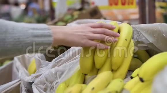 女孩在杂货店柜台拿成熟的香蕉视频的预览图
