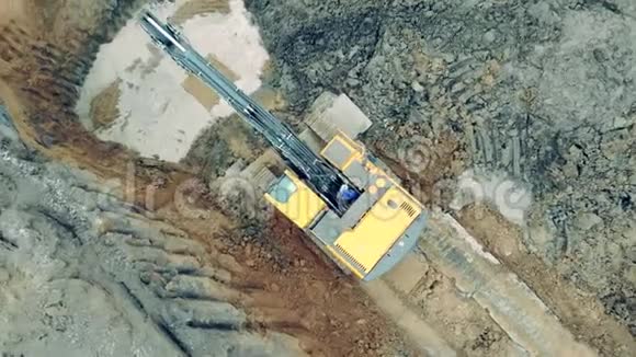 黄色挖掘机在职业生涯中工作把泥土倒进一个洞里工业采石场施工挖掘机工作视频的预览图