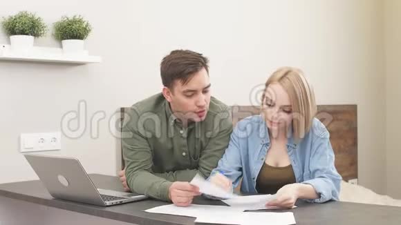 一对年轻的白种人夫妇在家里检查公用事业账单分析视频的预览图