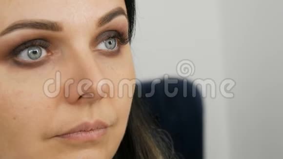 年轻美丽的女人的脸用米黄色的色调化妆烟熏的眼睛视频的预览图