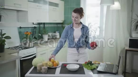 良好的饮食习惯年轻快乐的女人站在餐桌旁的厨房里用卷尺测量她的腰视频的预览图