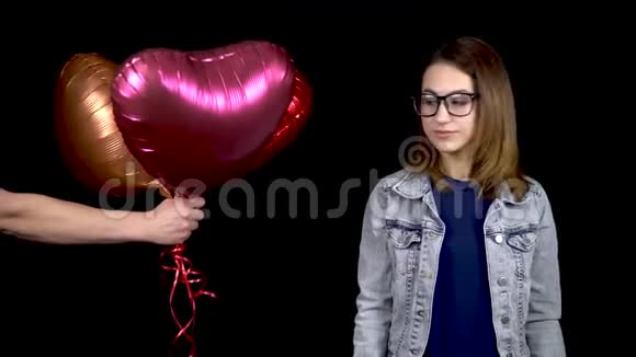 心形气球被送给了一个年轻的女人那个女人很惊讶拿了装有氦气的气球视频的预览图