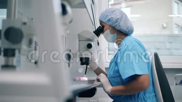 女实验室专家正在实验室用显微镜工作视频的预览图