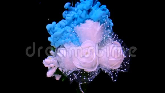 美丽的婚礼花束白色玫瑰和蓝色水彩墨水在水中的黑色背景视频的预览图